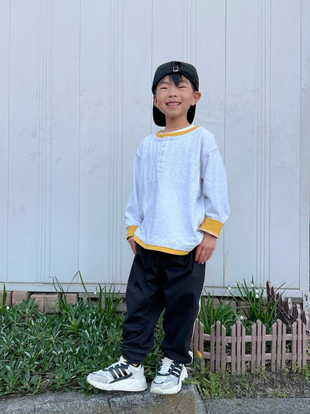 イエロー系のTシャツ/カットソー、ブラック系のその他パンツ、ホワイト系のスニーカーを着用したキッズの春コーディネートの2枚目の写真