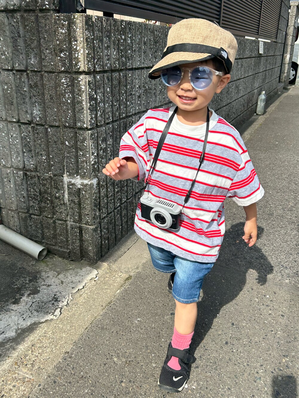 グレー系のTシャツ/カットソー、ブルー系のデニムパンツ、ブラック系のスニーカーを着用したキッズの春コーディネートの2枚目の写真