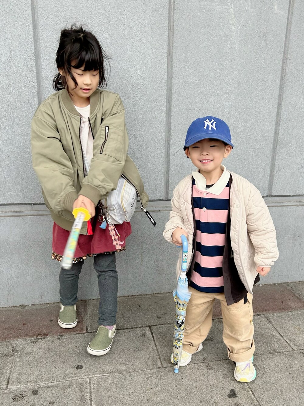 ピンク系のポロシャツ、ベージュ系のカーゴパンツ、ホワイト系のスニーカーを着用したキッズの春コーディネートの4枚目の写真