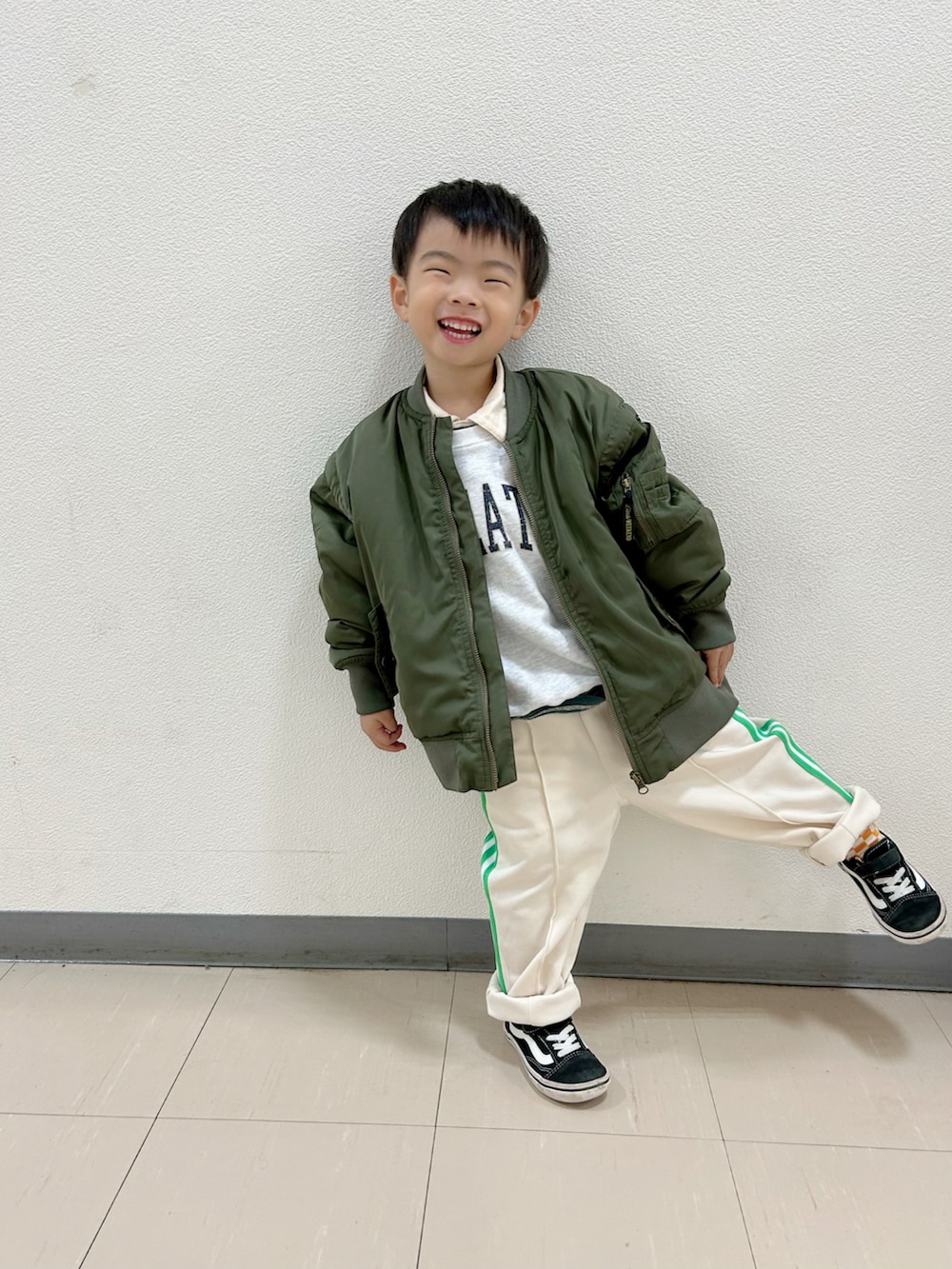 グレー系のスウェット、グリーン系のポロシャツ、グリーン系のMA-1を着用したキッズの秋コーディネートの2枚目の写真