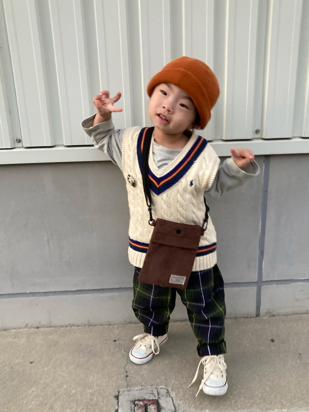 グリーン系のTシャツ/カットソー、ブラウン系のショルダーバッグ、グリーン系のパンツを着用したキッズの秋コーディネートの2枚目の写真