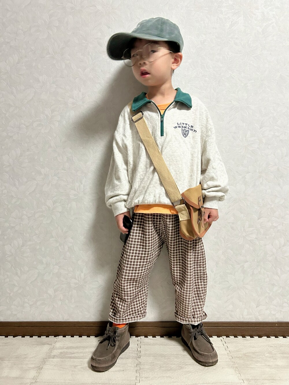 オレンジ系のタンクトップ、グレー系のスウェット、ブラウン系のパンツを着用したキッズの秋コーディネートの3枚目の写真