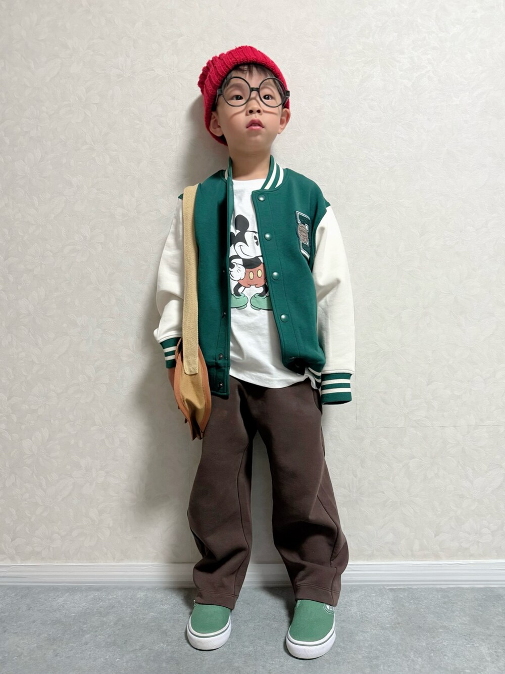 ブラウン系のショルダーバッグ、グリーン系のスリッポン、ホワイト系のTシャツ/カットソーを着用したキッズの秋コーディネートの3枚目の写真