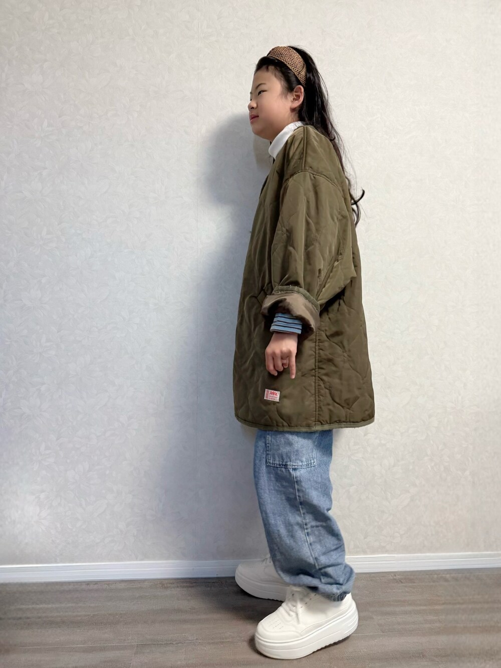 ブルー系のカーゴパンツ、シルバー系のショルダーバッグ、ブラウン系のノーカラージャケットを着用したキッズの春コーディネートの2枚目の写真