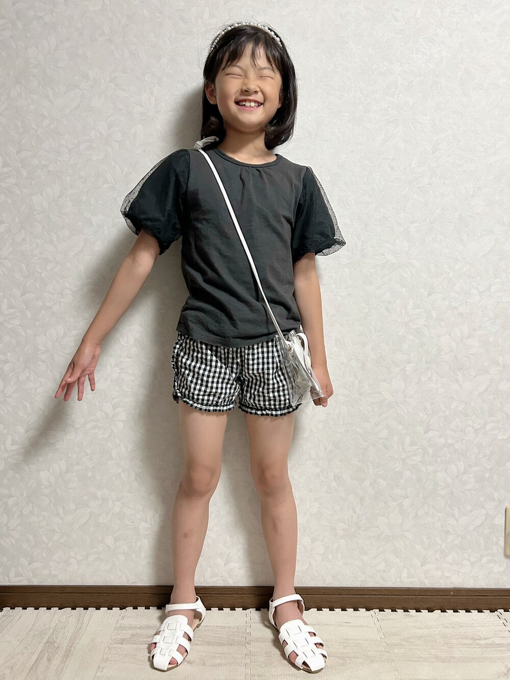 ブラック系のシャツ/ブラウス、ホワイト系のショルダーバッグ、ブラック系のパンツを着用したキッズの夏コーディネートの2枚目の写真