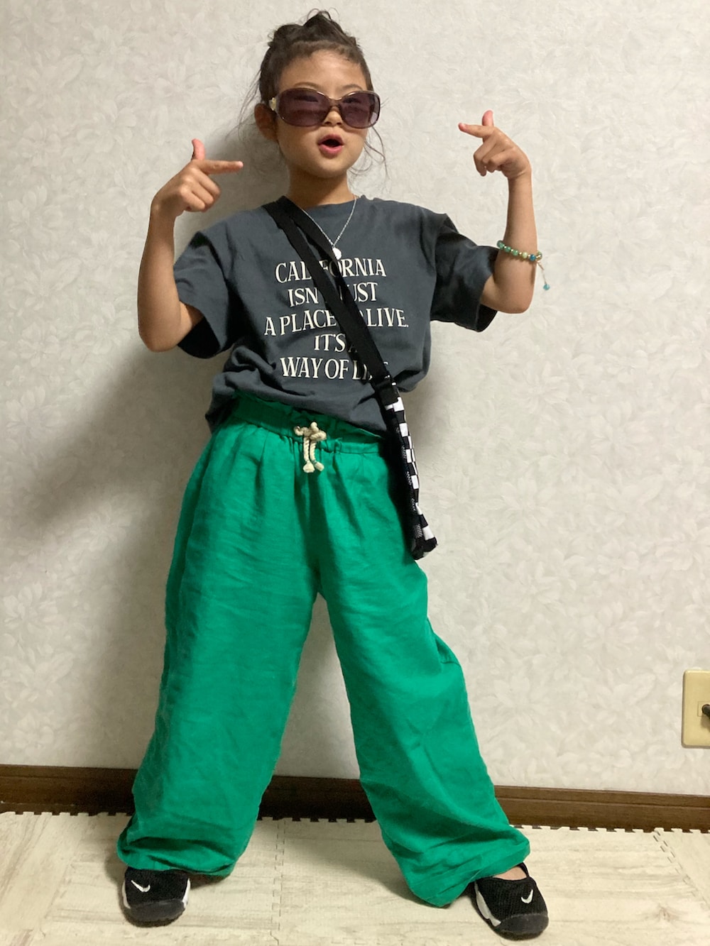 グレー系のTシャツ/カットソー、グリーン系のパンツ、ブラック系のスニーカーを着用したキッズの夏コーディネートの2枚目の写真