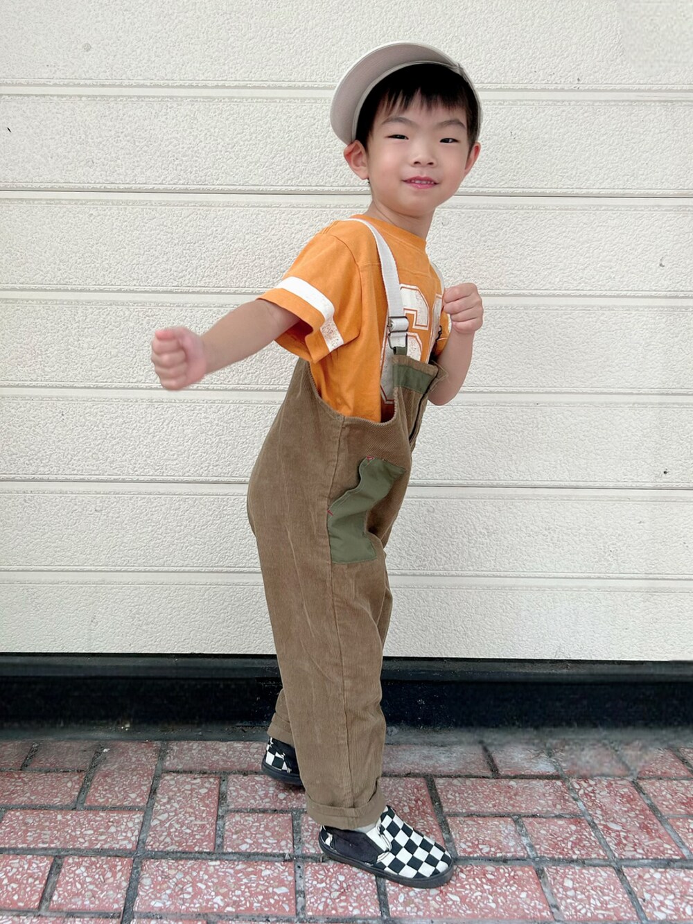 オレンジ系のTシャツ/カットソー、グリーン系のサロペット/オーバーオール、その他のスリッポンを着用したキッズの秋コーディネートの5枚目の写真