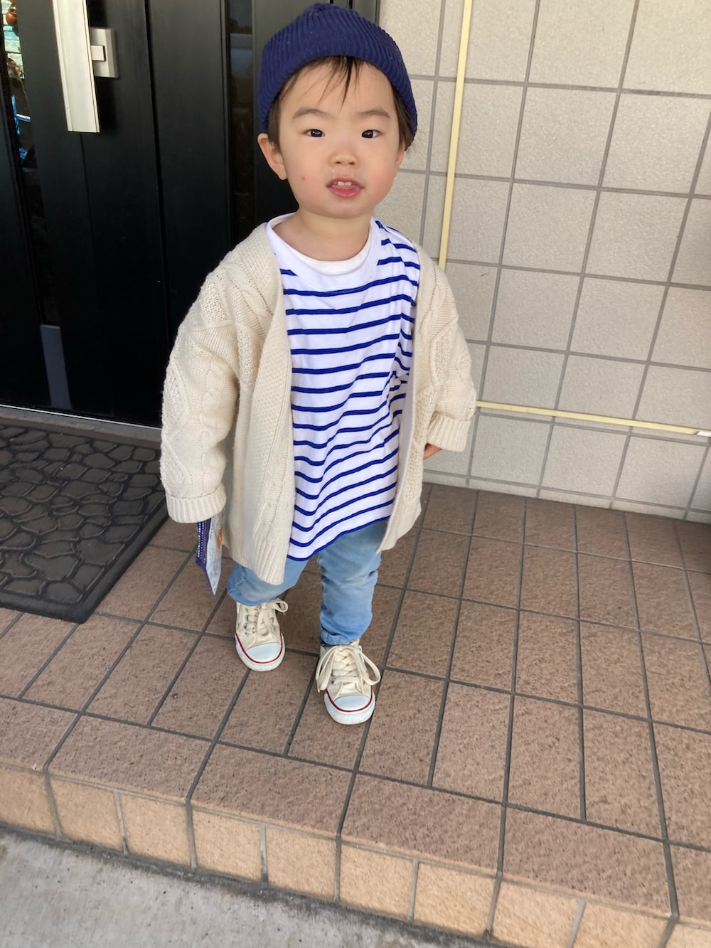 ブルー系のTシャツ/カットソー、ホワイト系のカーディガン/ボレロ、ブルー系のデニムパンツを着用したキッズの冬コーディネートの2枚目の写真