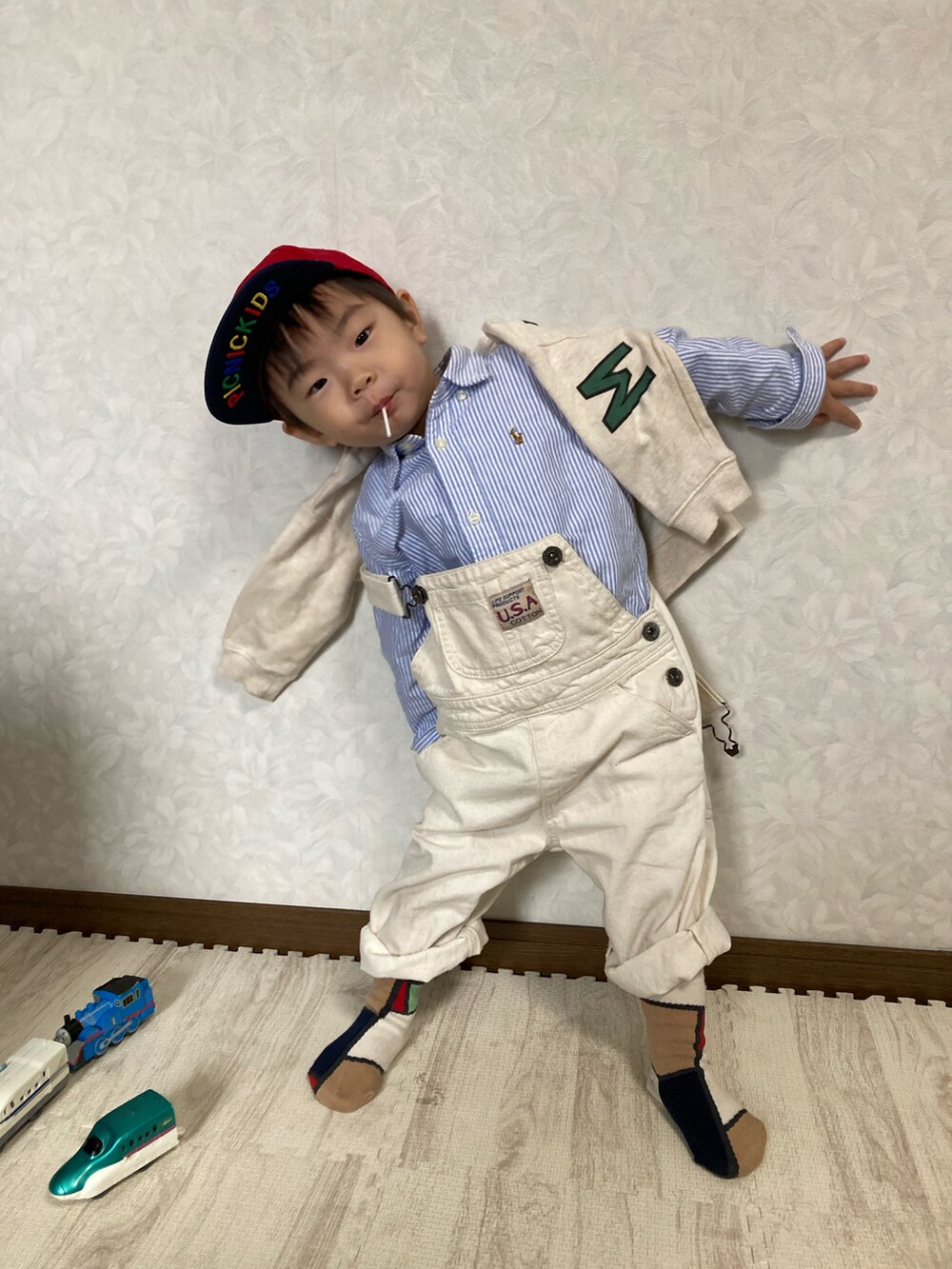 ブルー系のシャツ/ブラウス、ベージュ系のスウェット、ホワイト系のサロペット/オーバーオールを着用したキッズの春コーディネートの2枚目の写真