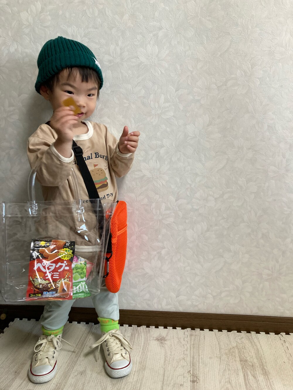 ベージュ系のTシャツ/カットソー、グリーン系のパンツ、オレンジ系のショルダーバッグを着用したキッズの春コーディネートの4枚目の写真