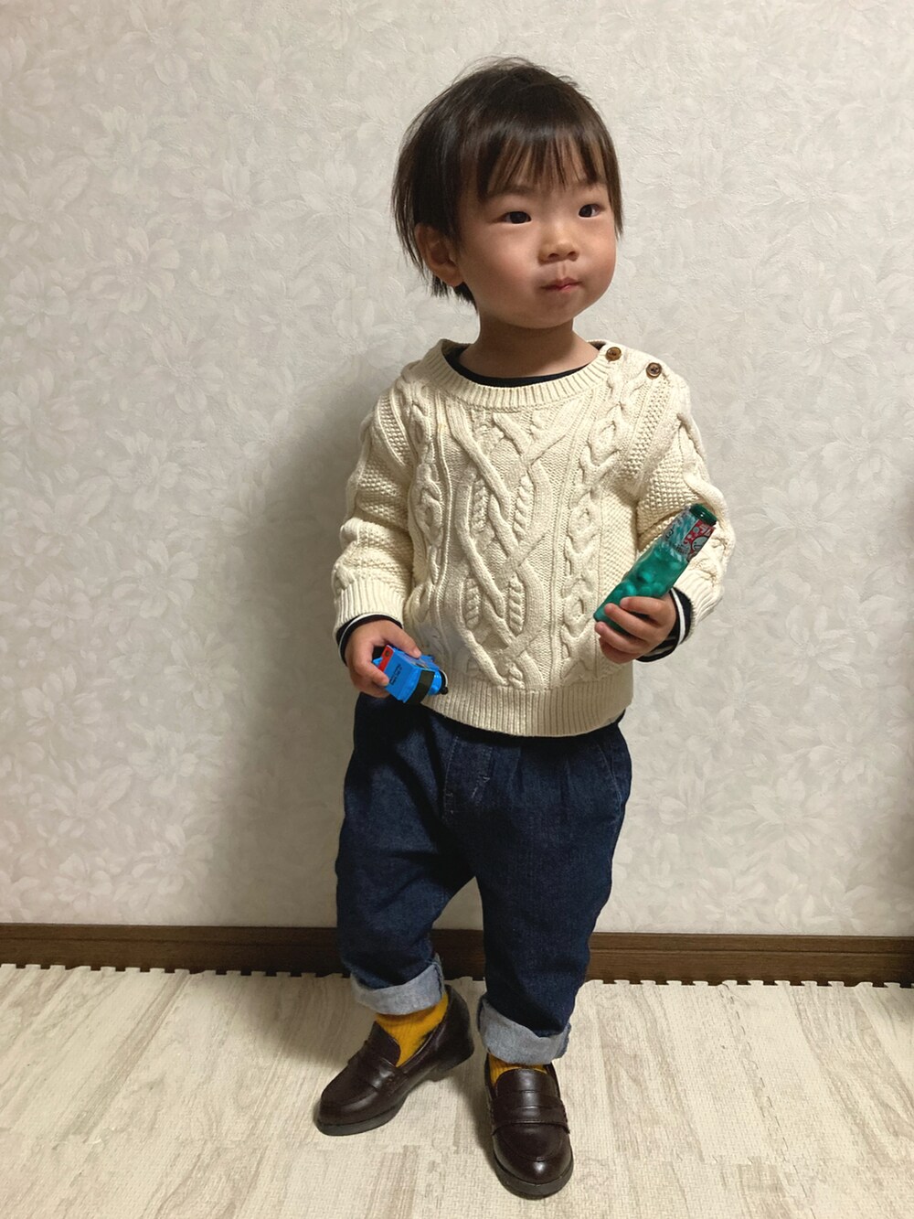 ホワイト系のTシャツ/カットソー、ホワイト系のニット/セーター、ブルー系のデニムパンツを着用したキッズの冬コーディネートの3枚目の写真