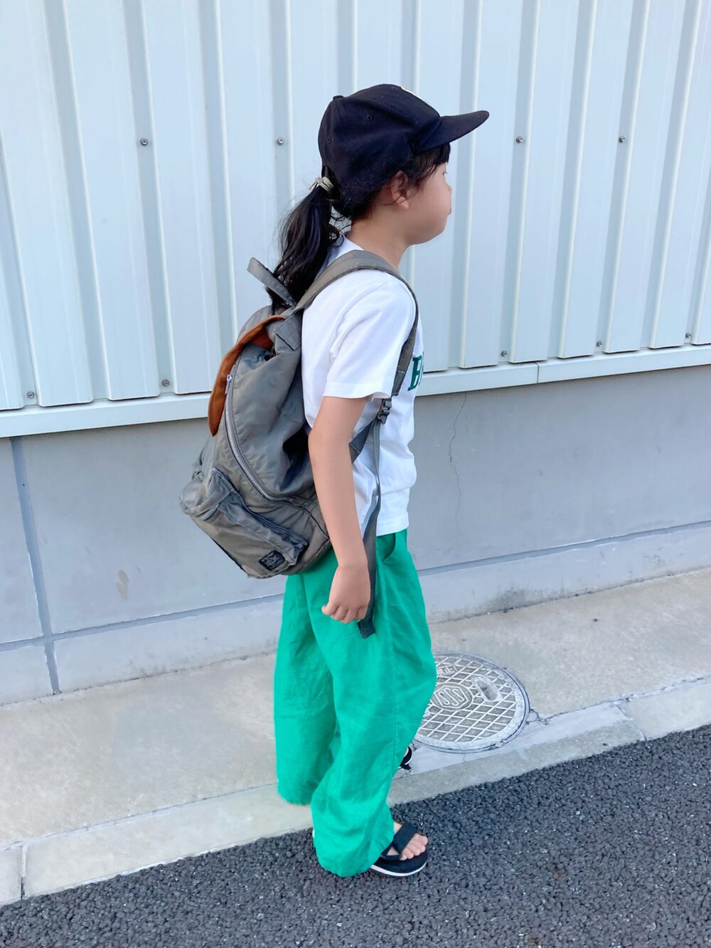 ホワイト系のTシャツ/カットソー、グレー系のバックパック/リュック、グリーン系のパンツを着用したキッズの夏コーディネートの3枚目の写真