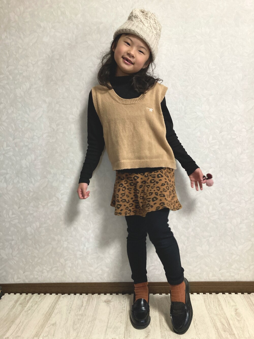 ブラック系のニット/セーター、ベージュ系のベスト、ブラウン系のスカートを着用したキッズの冬コーディネートの3枚目の写真