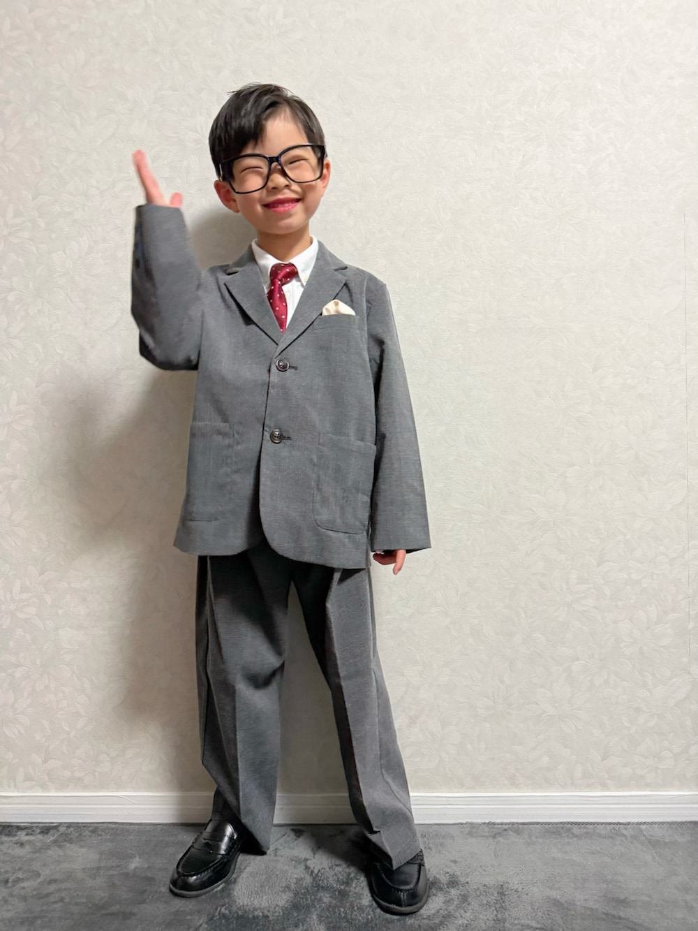 グレー系のスーツセット、ブラック系のランドセル、その他のその他を着用したキッズの冬コーディネートの3枚目の写真