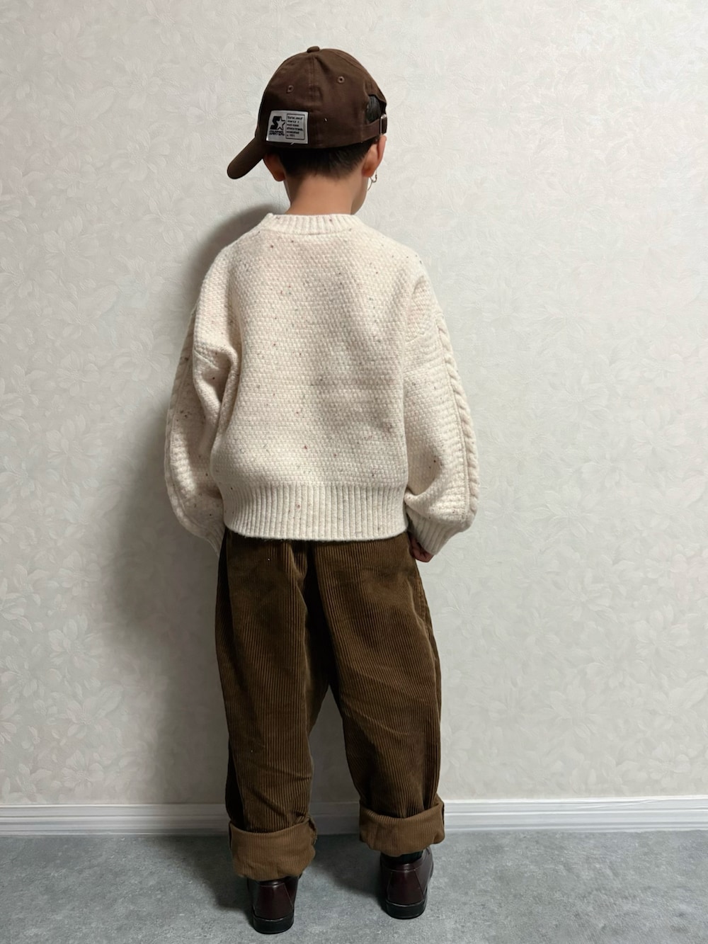 ブラウン系のローファー、ホワイト系のニット/セーター、ブラウン系のパンツを着用したキッズの秋コーディネートの5枚目の写真