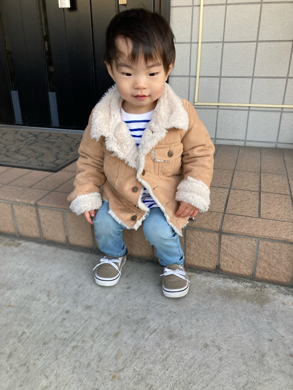 ベージュ系のジャケット/アウター、ブラウン系のスニーカー、ブルー系のキャップを着用したキッズの春コーディネートの4枚目の写真