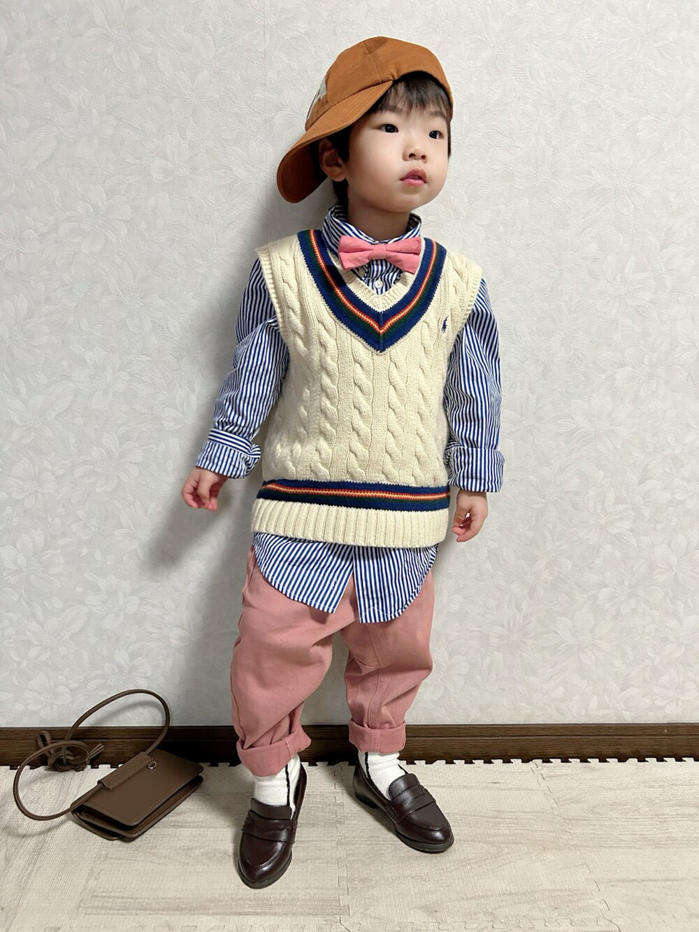 ブルー系のシャツ/ブラウス、ホワイト系のベスト、レッド系の蝶ネクタイを着用したキッズの冬コーディネートの2枚目の写真