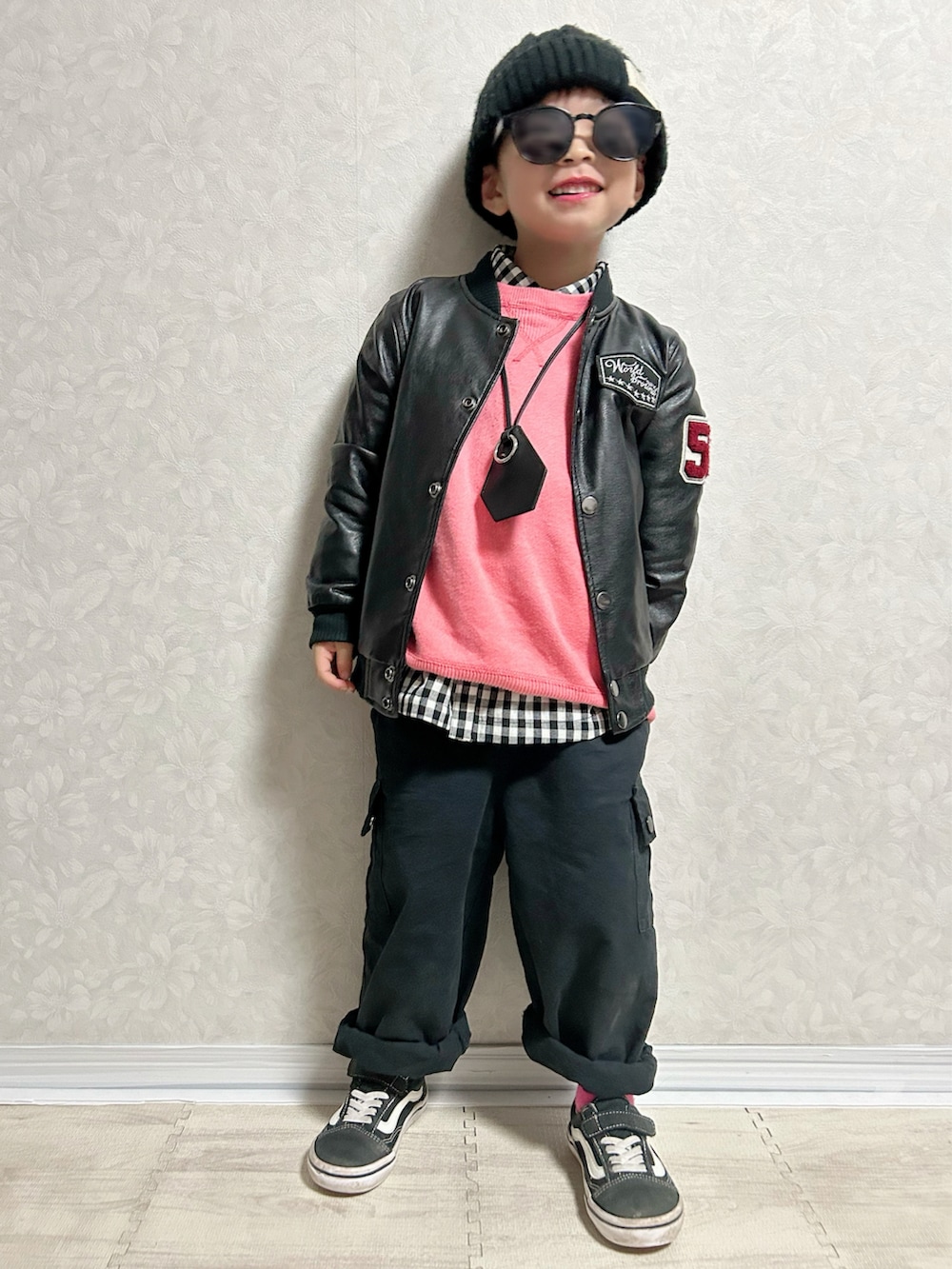 ブラック系のシャツ/ブラウス、ピンク系のニット/セーター、ブラック系のライダースジャケットを着用したキッズの秋コーディネートの2枚目の写真