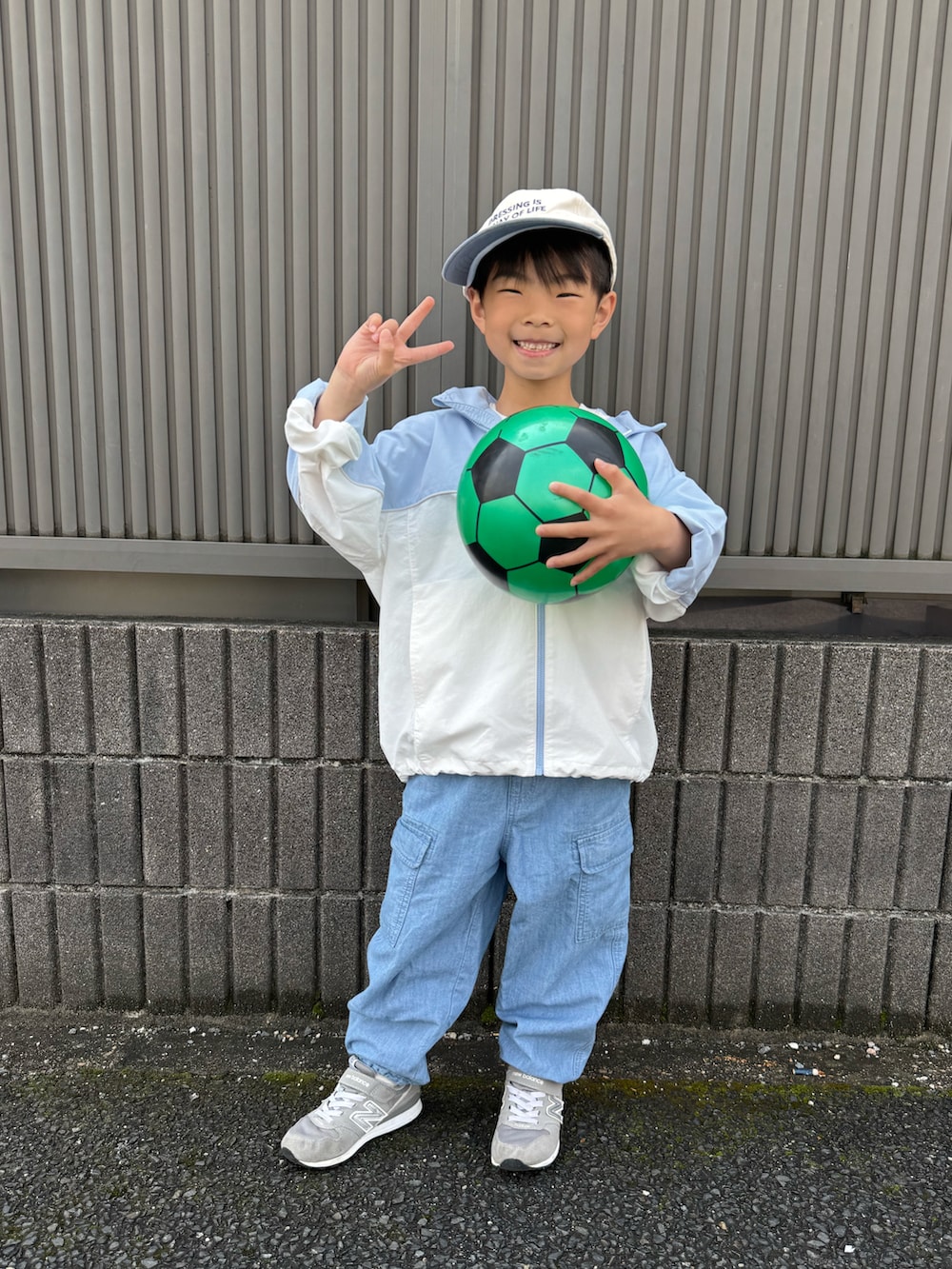 グリーン系のTシャツ/カットソー、ブルー系のナイロンジャケット、ブルー系のパンツを着用したキッズの春コーディネートの2枚目の写真