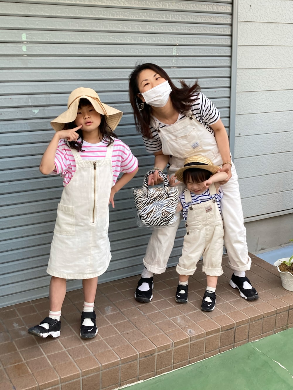 ピンク系のTシャツ/カットソー、ホワイト系のサロペット/オーバーオール、ブラック系のスニーカーを着用したキッズの春コーディネートの4枚目の写真