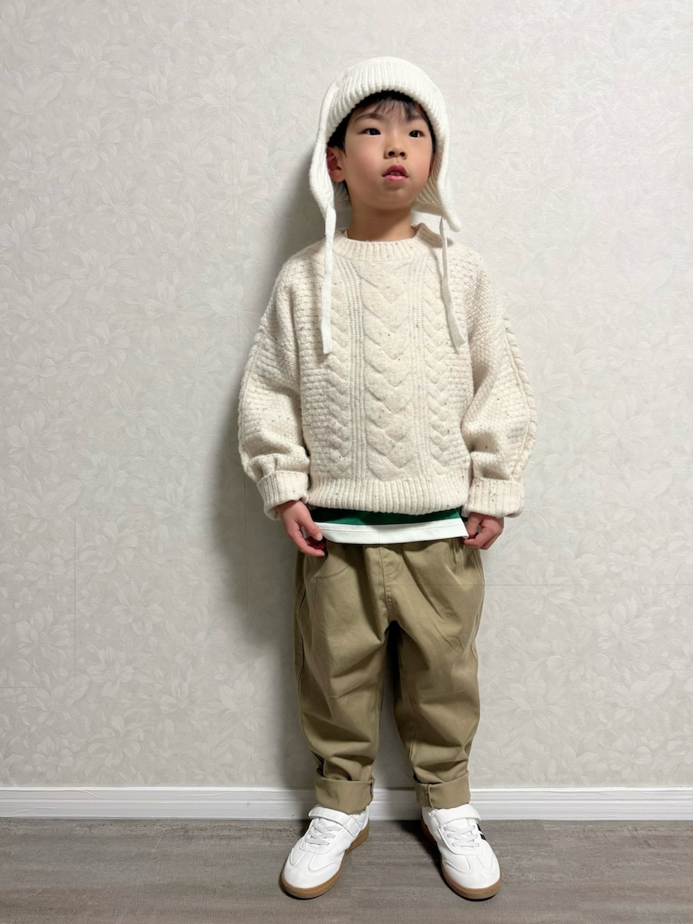 ホワイト系のニット/セーター、グリーン系のTシャツ/カットソー、レッド系のダウンジャケット/コートを着用したキッズの冬コーディネートの2枚目の写真