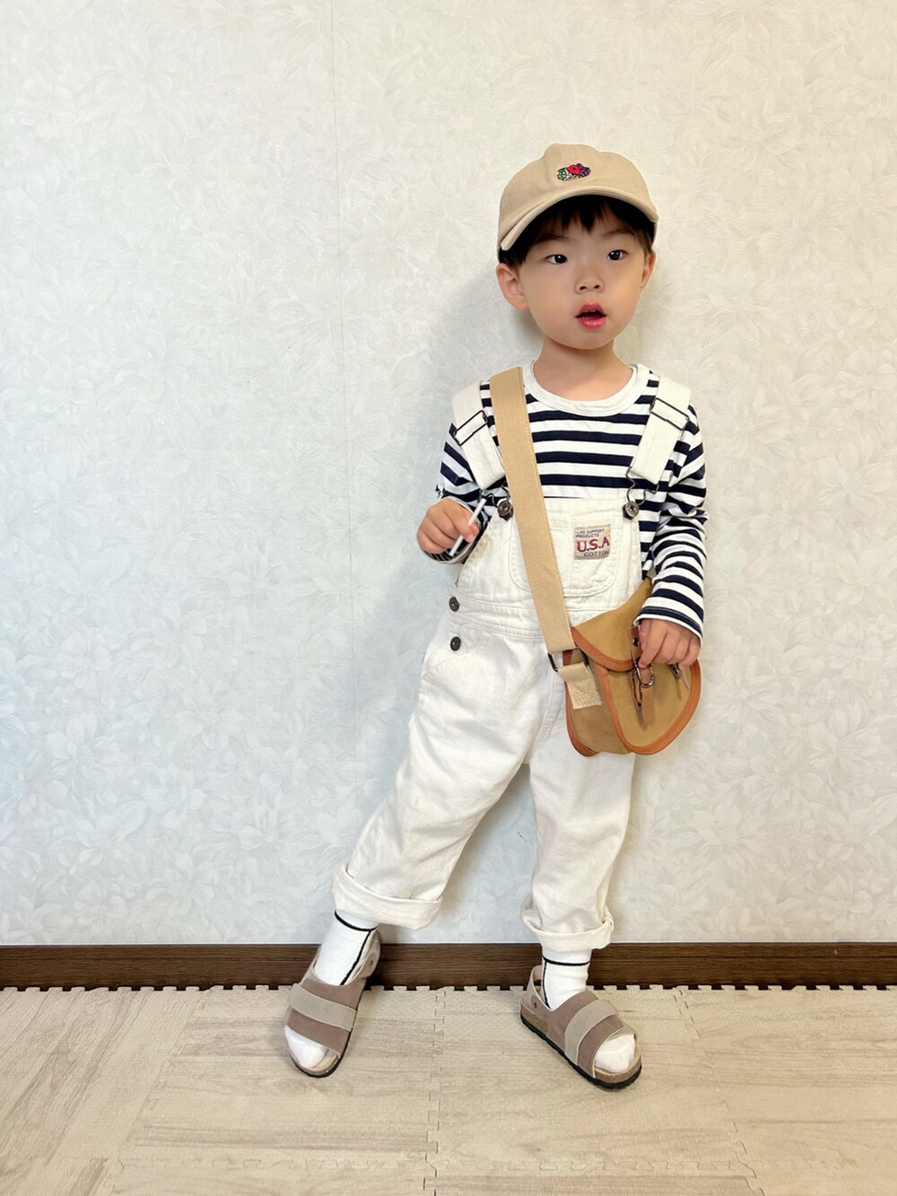 ブルー系のTシャツ/カットソー、ホワイト系のサロペット/オーバーオール、ブラウン系のショルダーバッグを着用したキッズの春コーディネートの3枚目の写真