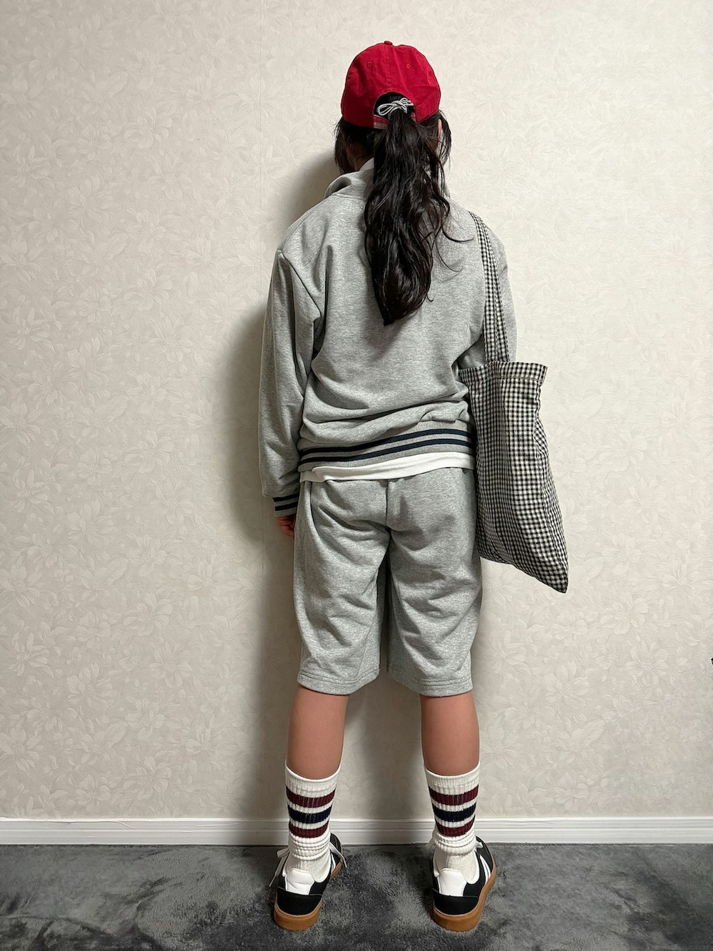 グレー系のセットアップ、ホワイト系のTシャツ/カットソー、ブラック系のトートバッグを着用したキッズの冬コーディネートの4枚目の写真