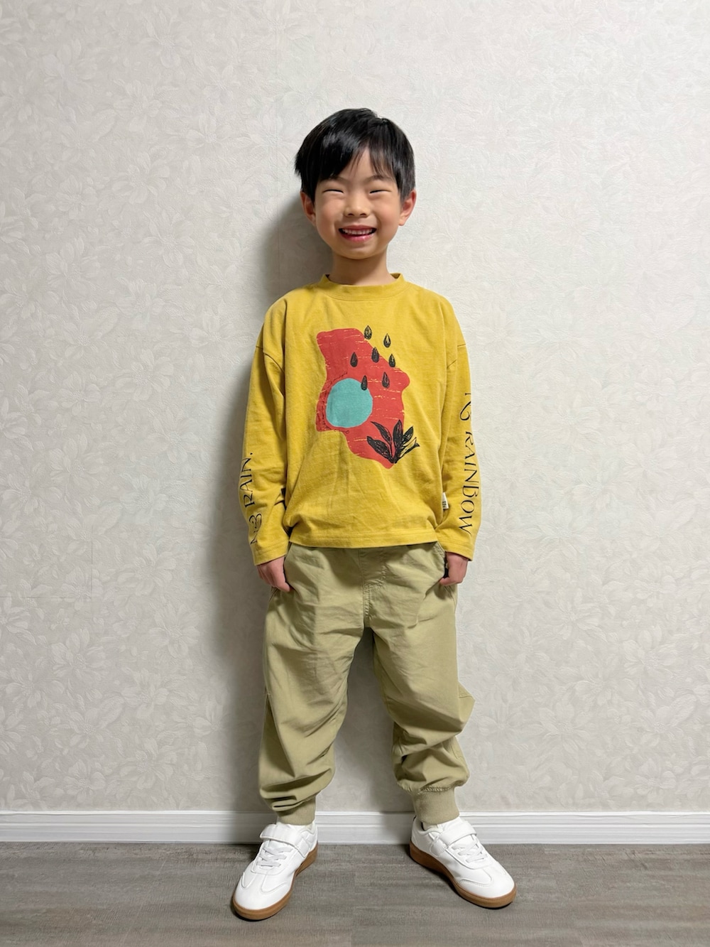 イエロー系のTシャツ/カットソー、ベージュ系のその他パンツ、ブラック系のスニーカーを着用したキッズの冬コーディネートの3枚目の写真