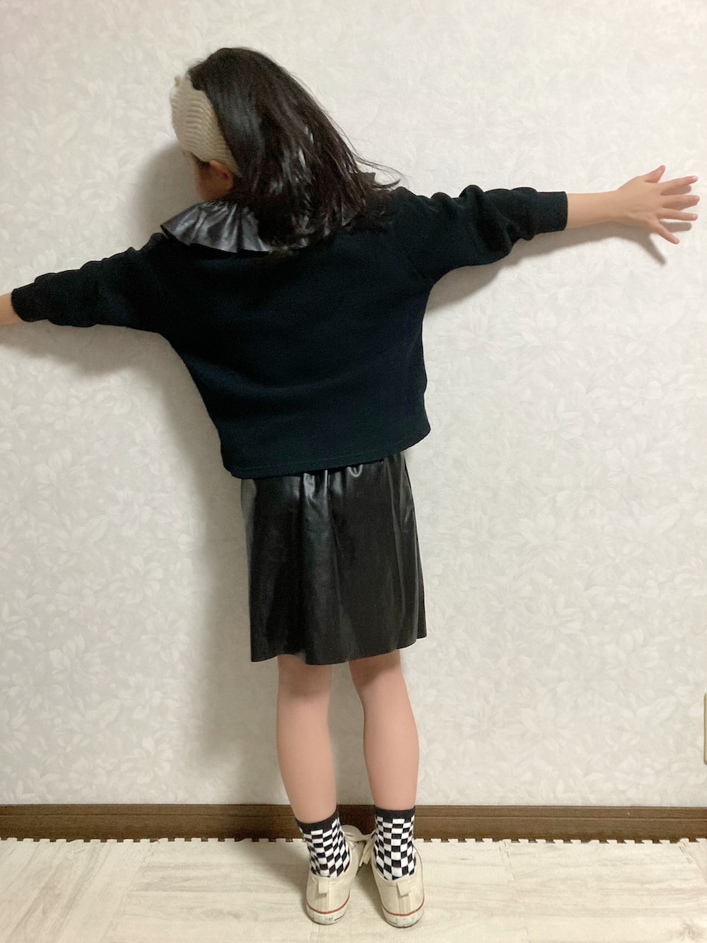 ブラック系のTシャツ/カットソー、ブラック系のスカート、ホワイト系のスニーカーを着用したキッズの冬コーディネートの5枚目の写真