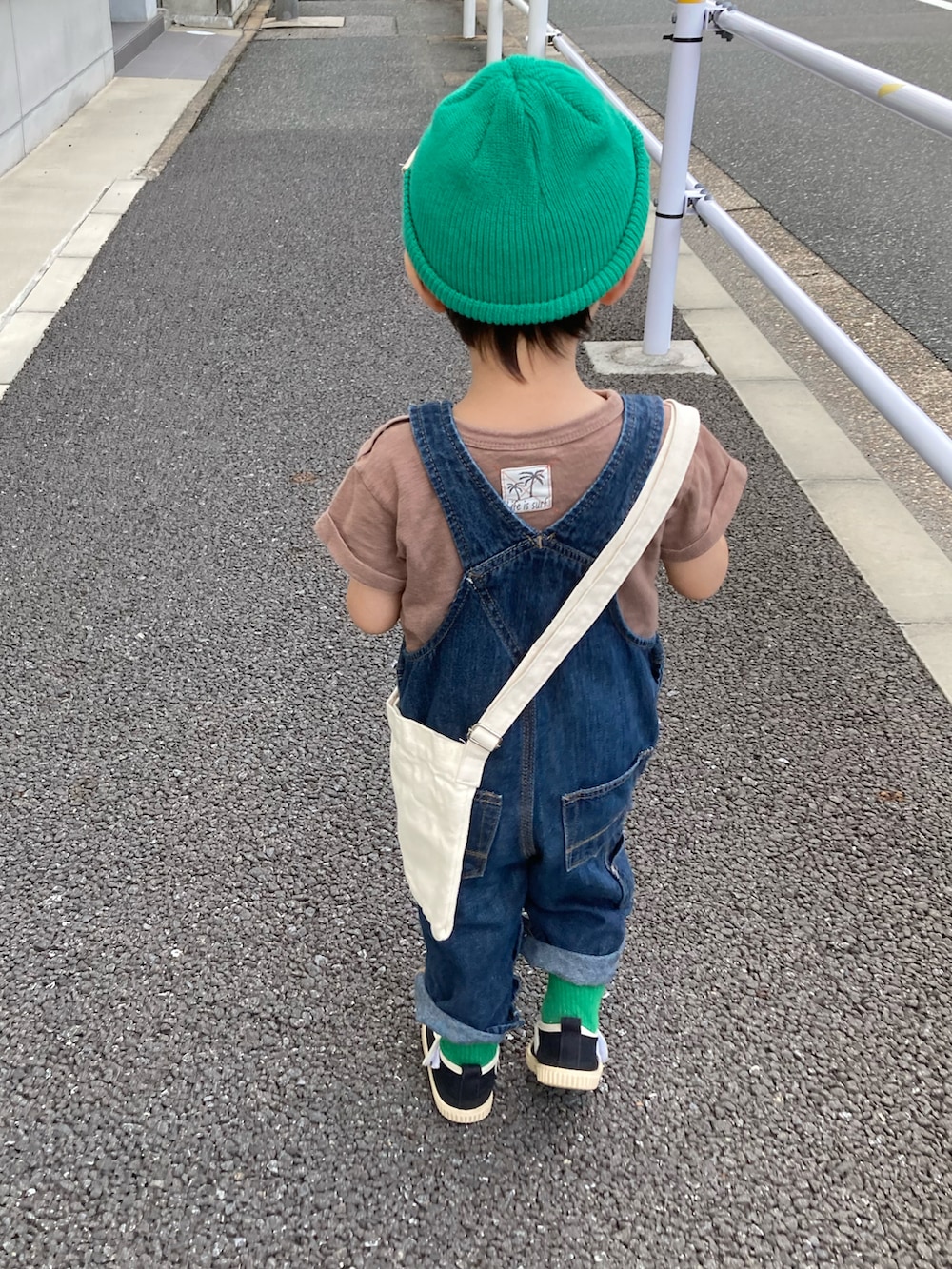 ブラウン系のTシャツ/カットソー、ブルー系のサロペット/オーバーオール、ホワイト系のショルダーバッグを着用したキッズの夏コーディネートの4枚目の写真