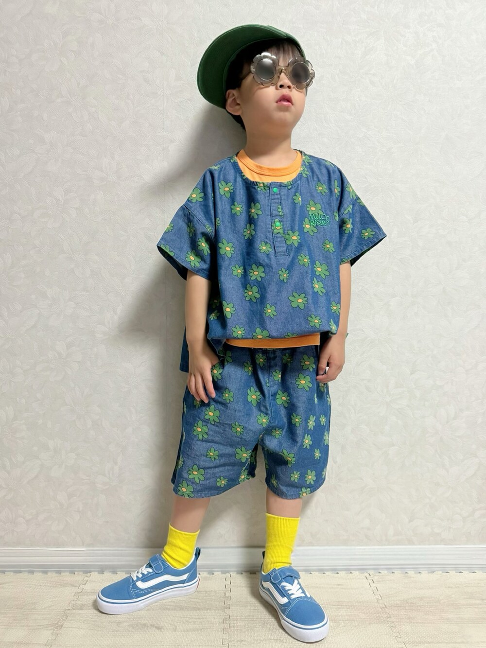 オレンジ系のタンクトップ、ブルー系のスニーカー、ブルー系のセットアップを着用したキッズの夏コーディネートの2枚目の写真