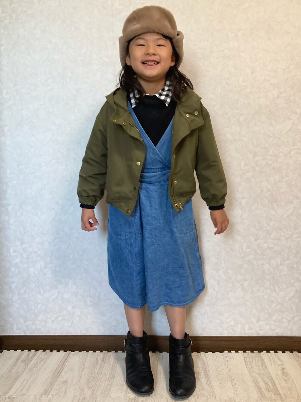 グリーン系のブルゾン、ブルー系のサロペット/オーバーオール、ブルー系のジャンパースカートを着用したキッズの冬コーディネートの2枚目の写真