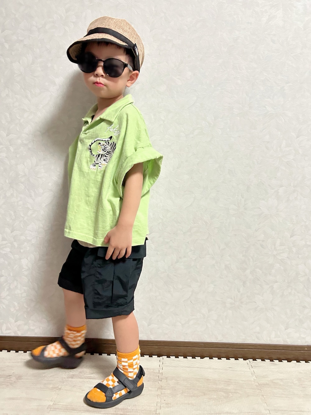 ベージュ系のタンクトップ、グリーン系のポロシャツ、ブラック系のカーゴパンツを着用したキッズの夏コーディネートの5枚目の写真