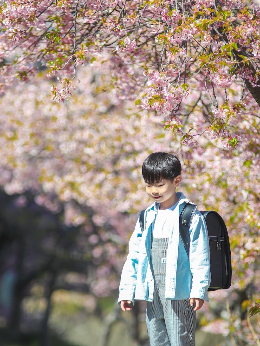 ブラック系のランドセル、グレー系のスニーカー、その他のサロペット/オーバーオールを着用したキッズの春コーディネートの2枚目の写真