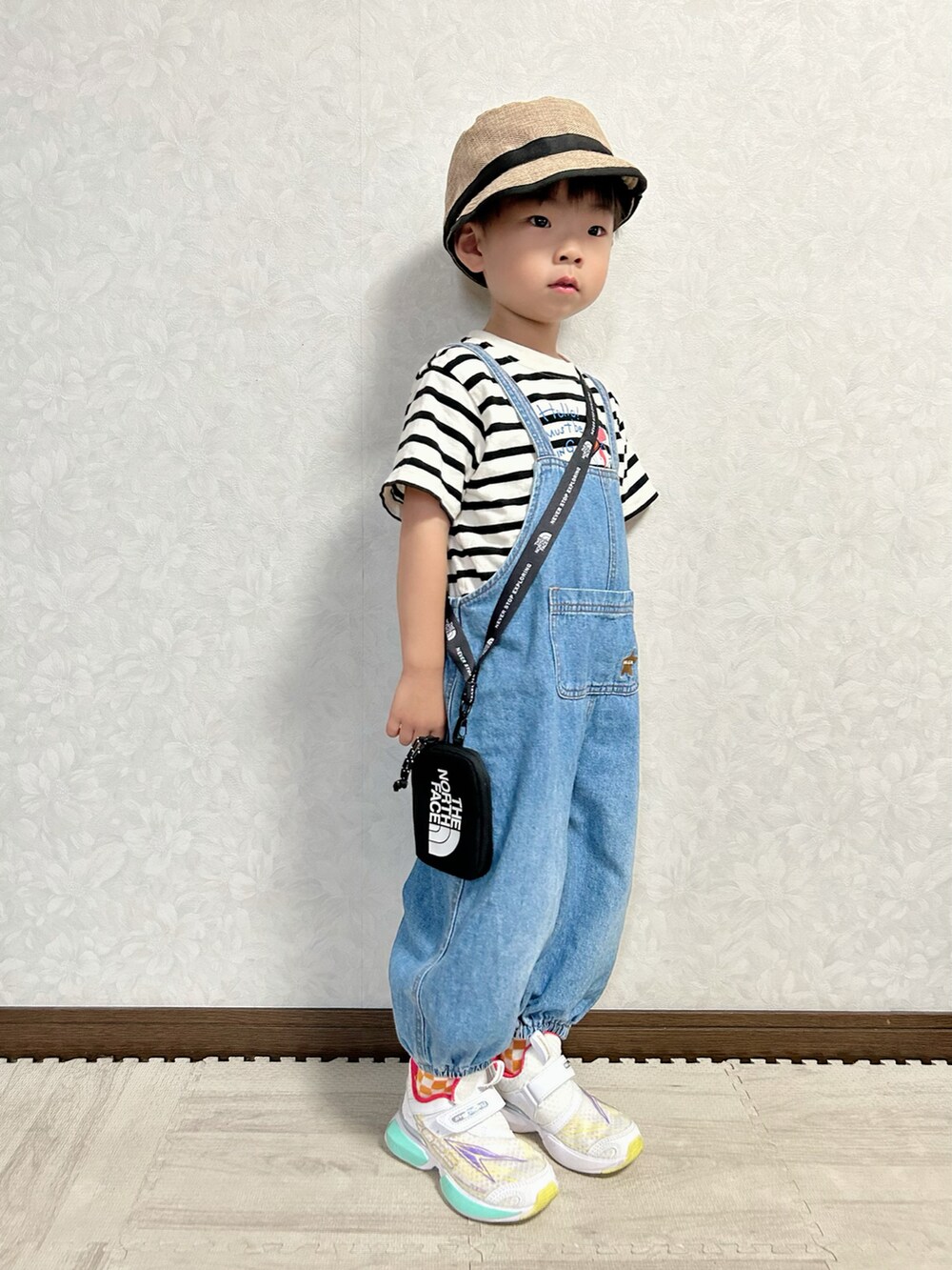 ベージュ系のTシャツ/カットソー、ブルー系のサロペット/オーバーオール、ホワイト系のスニーカーを着用したキッズの秋コーディネートの3枚目の写真