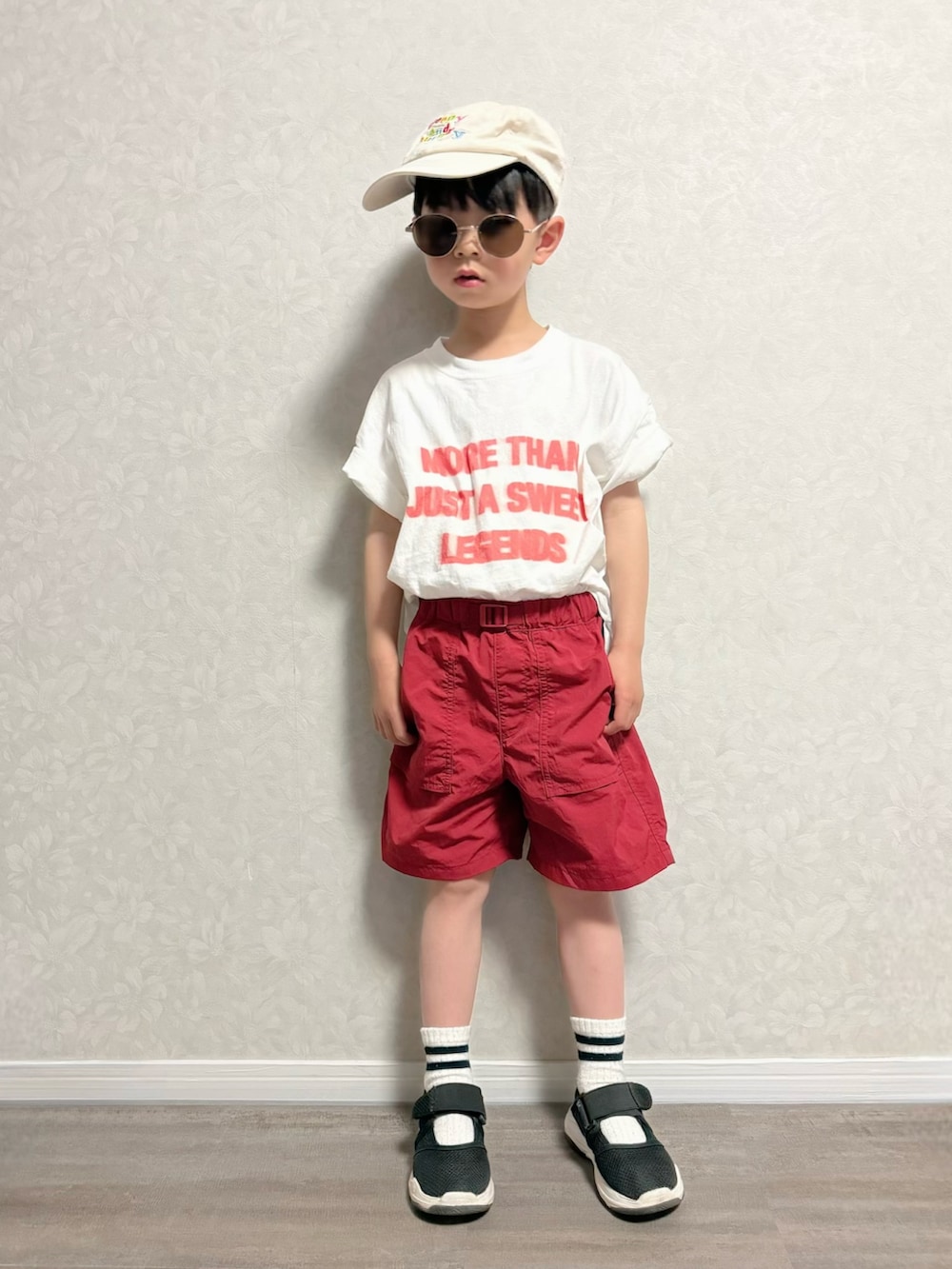 ブラック系のショルダーバッグ、ホワイト系のTシャツ/カットソー、レッド系のパンツを着用したキッズの春コーディネートの3枚目の写真