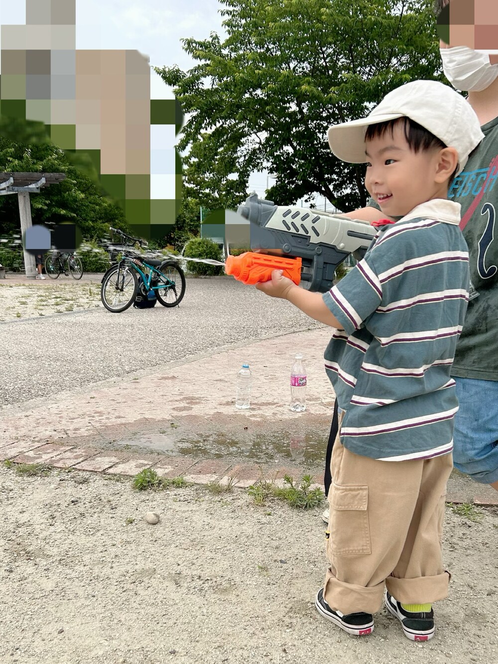 グリーン系のポロシャツ、ブラック系のスニーカー、ベージュ系のカーゴパンツを着用したキッズの夏コーディネートの5枚目の写真