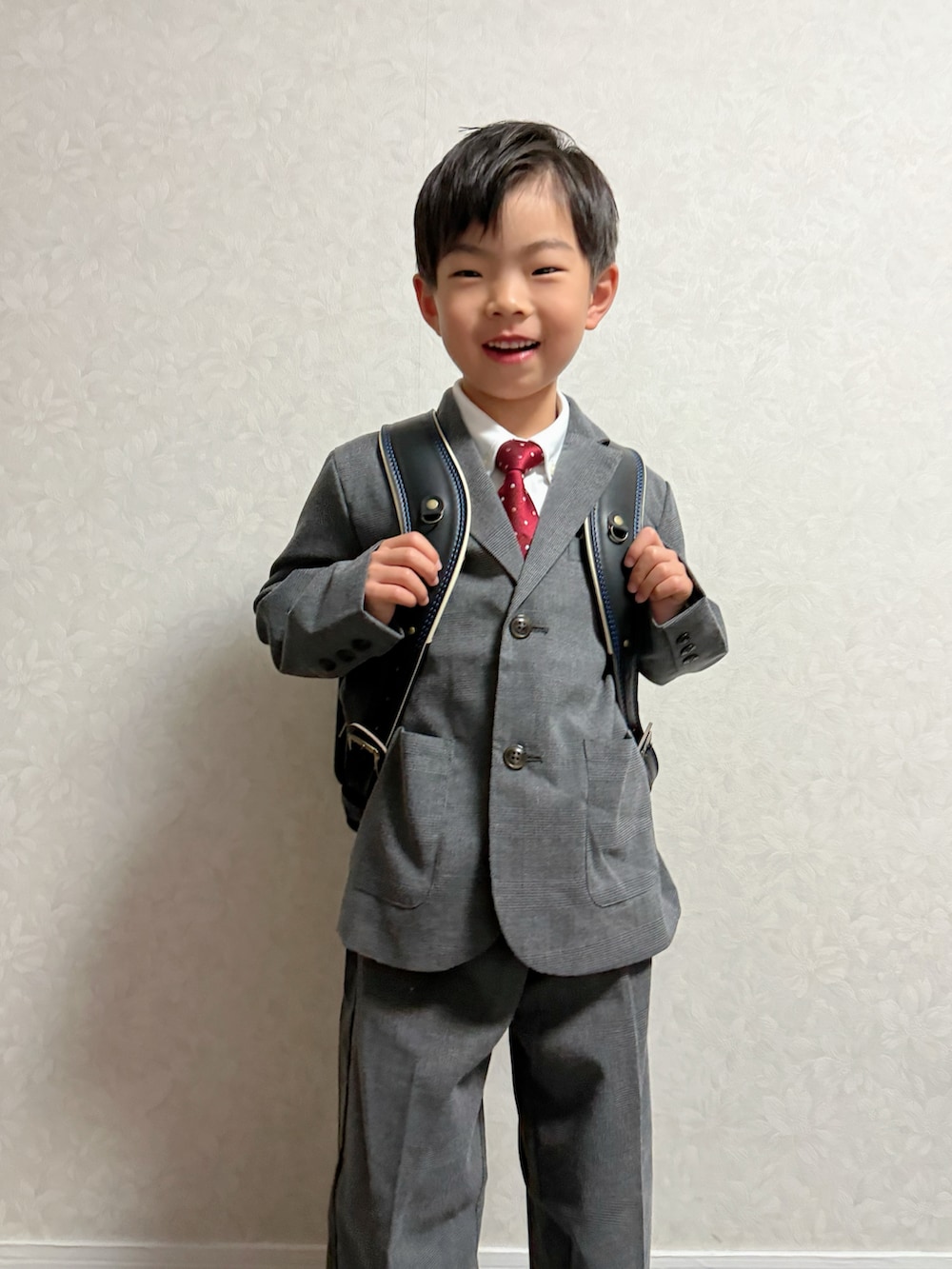 グレー系のスーツセット、ブラック系のランドセル、その他のその他を着用したキッズの冬コーディネートの4枚目の写真