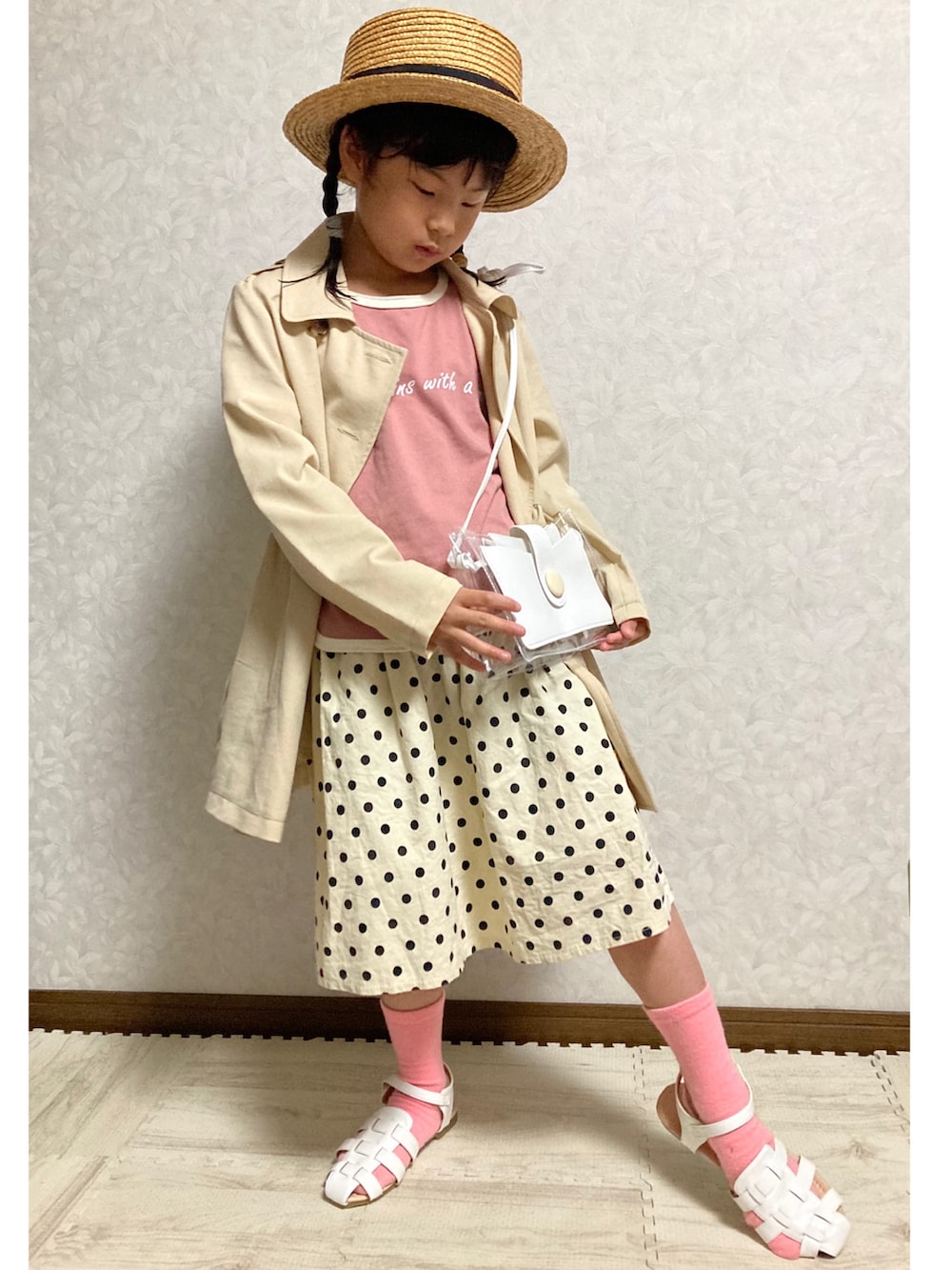 ピンク系のTシャツ/カットソー、ベージュ系のトレンチコート、ホワイト系のショルダーバッグを着用したキッズの春コーディネートの2枚目の写真