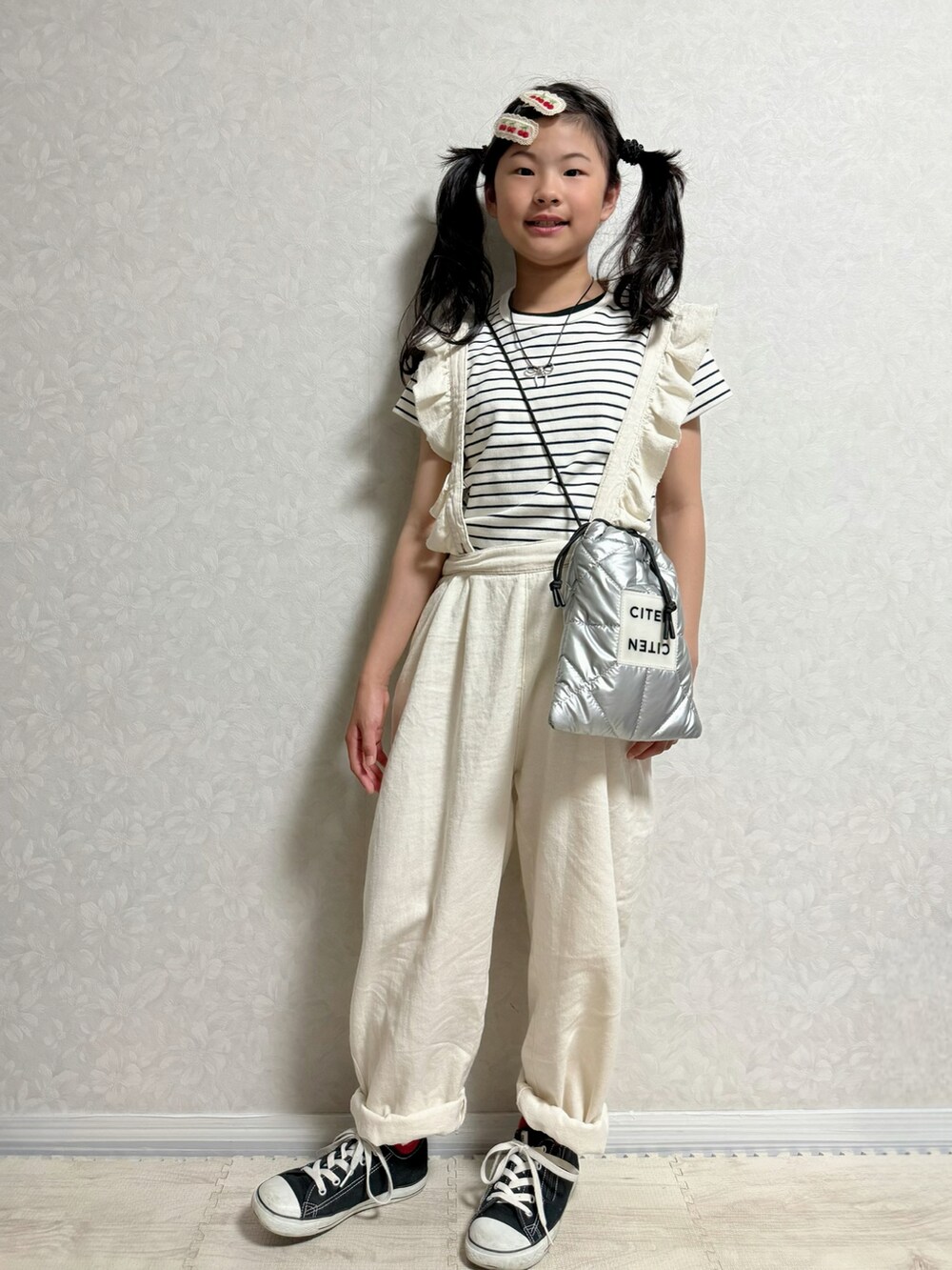 ホワイト系のサロペット/オーバーオール、シルバー系のショルダーバッグ、ブラック系のスニーカーを着用したキッズの春コーディネートの2枚目の写真
