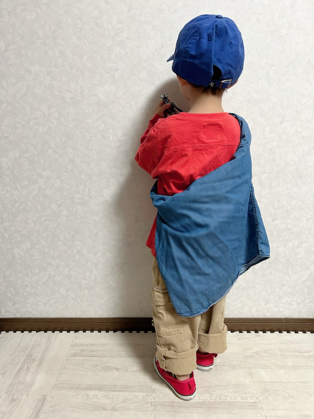 レッド系のTシャツ/カットソー、ブルー系のシャツ/ブラウス、ベージュ系のカーゴパンツを着用したキッズの秋コーディネートの3枚目の写真