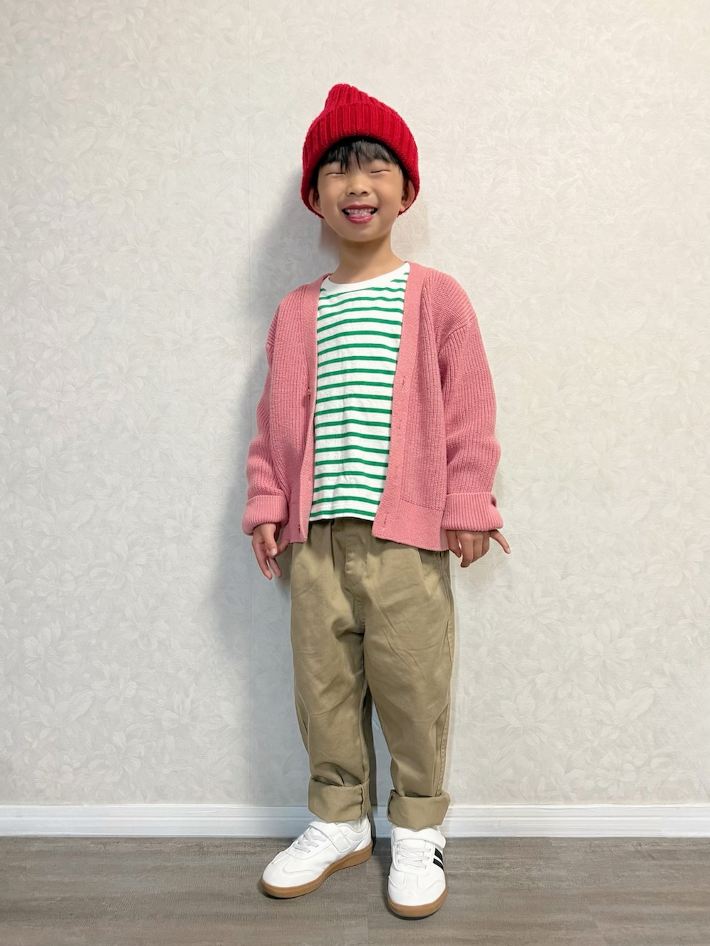 グリーン系のTシャツ/カットソー、ピンク系のカーディガン/ボレロ、ベージュ系のチノパンツを着用したキッズの春コーディネートの2枚目の写真