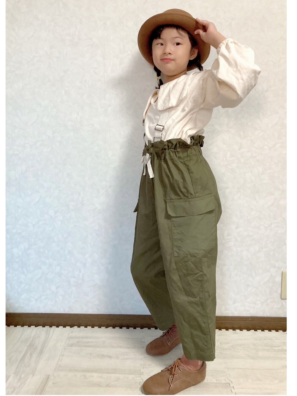 ホワイト系のスウェット、グリーン系のサロペット/オーバーオール、ブラウン系のドレスシューズを着用したキッズの秋コーディネートの3枚目の写真