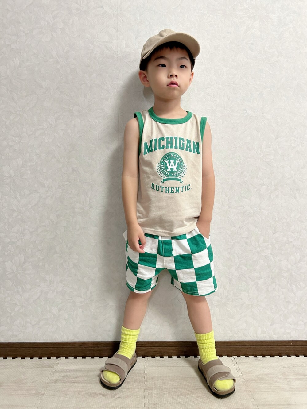 ベージュ系のタンクトップ、グリーン系のパンツ、オレンジ系のショルダーバッグを着用したキッズの夏コーディネートの2枚目の写真