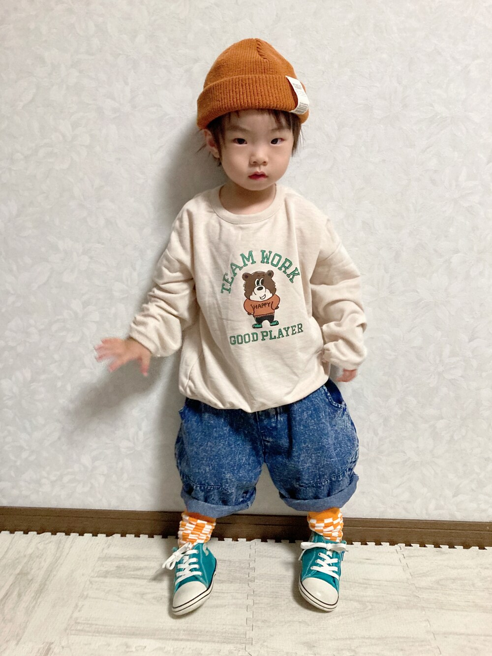 ベージュ系のスウェット、ブルー系のデニムパンツ、ホワイト系のスニーカーを着用したキッズの秋コーディネートの2枚目の写真