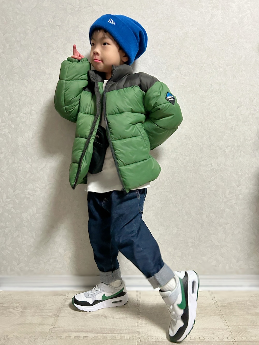 ホワイト系のTシャツ/カットソー、グリーン系のダウンジャケット/コート、ブルー系のデニムパンツを着用したキッズの冬コーディネートの4枚目の写真