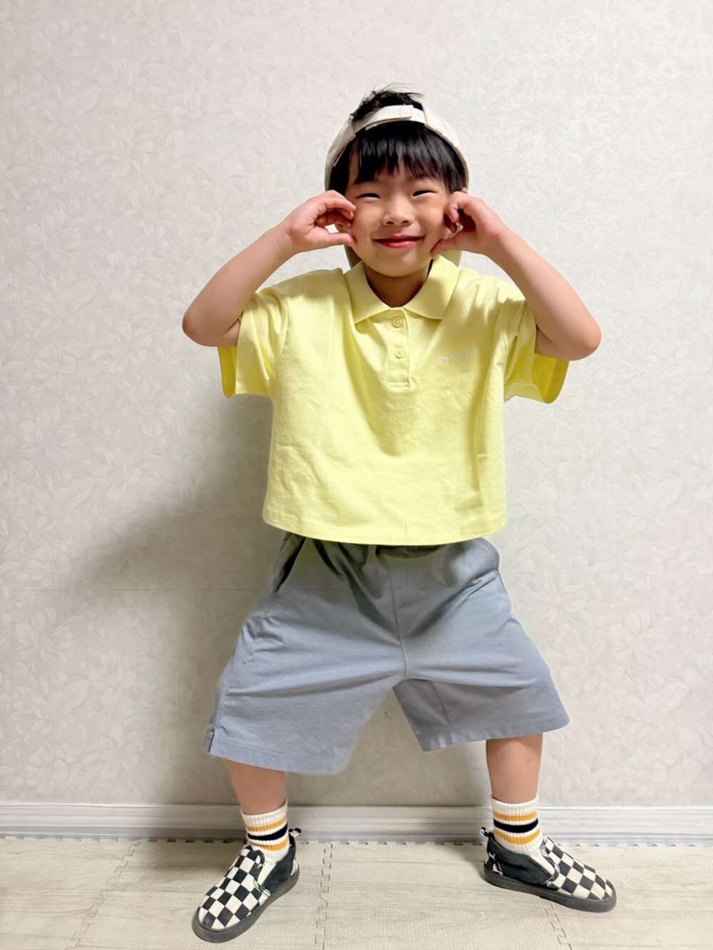 イエロー系のポロシャツ、グレー系のパンツ、その他のスリッポンを着用したキッズの夏コーディネートの4枚目の写真