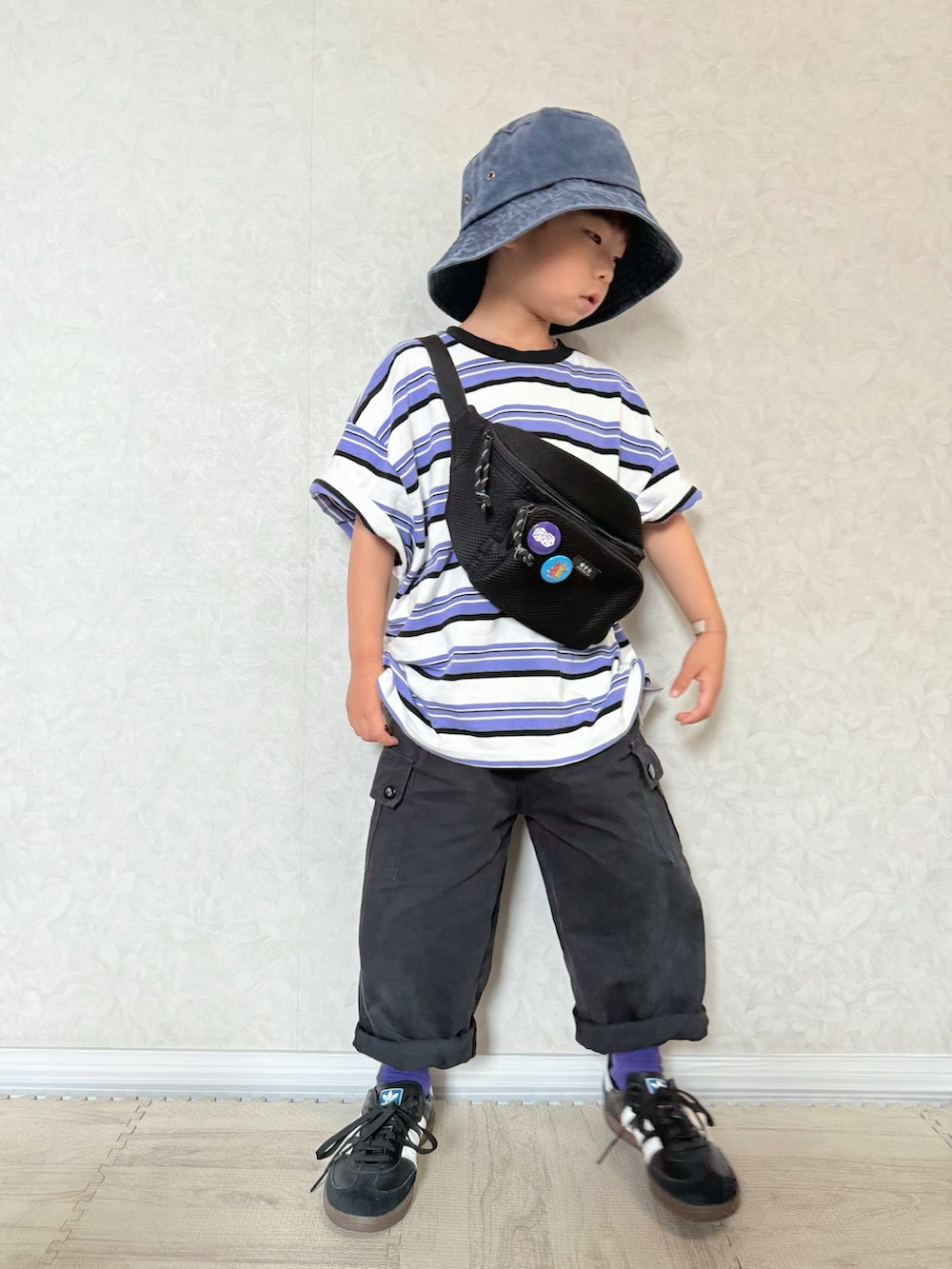 パープル系のTシャツ/カットソー、ブラック系のスニーカー、ブラック系のカーゴパンツを着用したキッズの夏コーディネートの3枚目の写真