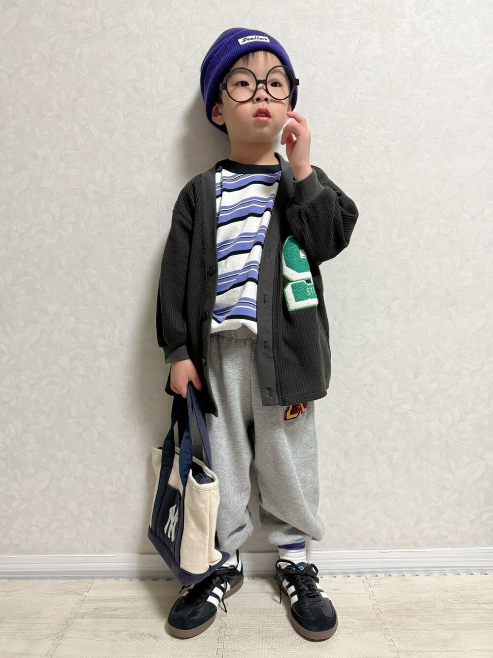 パープル系のTシャツ/カットソー、ブラック系のカーディガン/ボレロ、グレー系のスウェットパンツを着用したキッズの春コーディネートの2枚目の写真