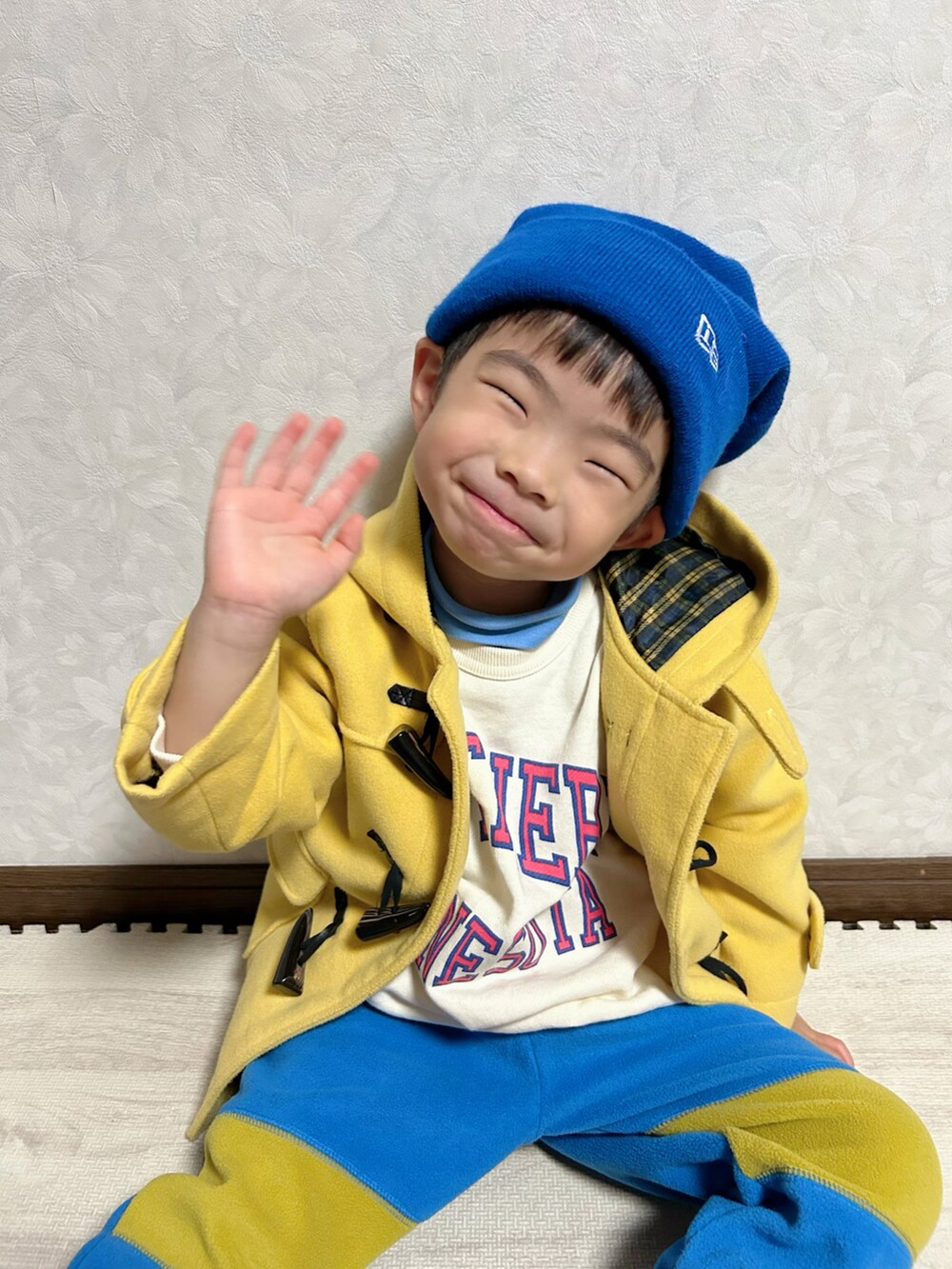 ホワイト系のスウェット、ブルー系のTシャツ/カットソー、イエロー系のダッフルコートを着用したキッズの冬コーディネートの2枚目の写真